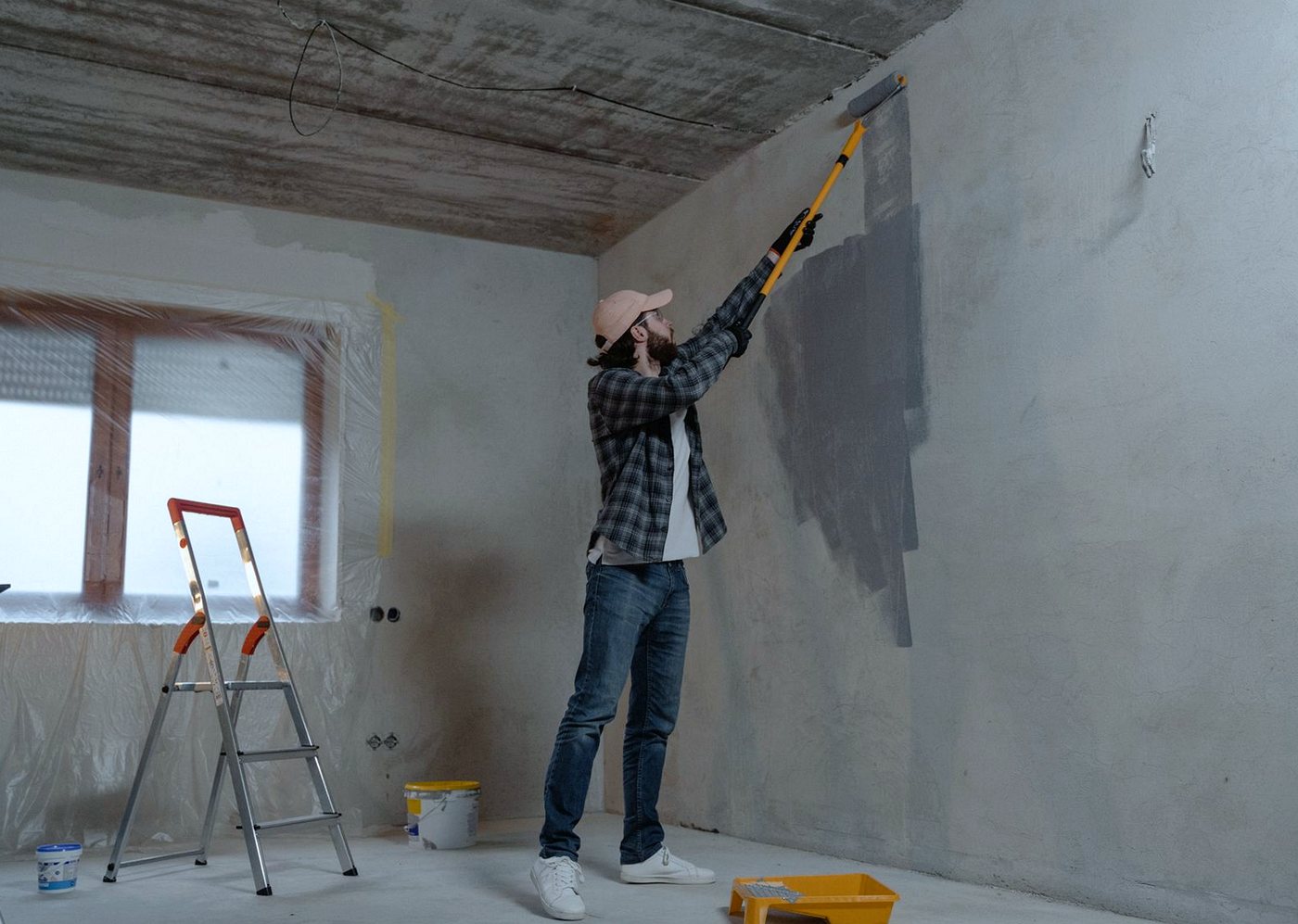 Decorator rolling paint onto an interior wall